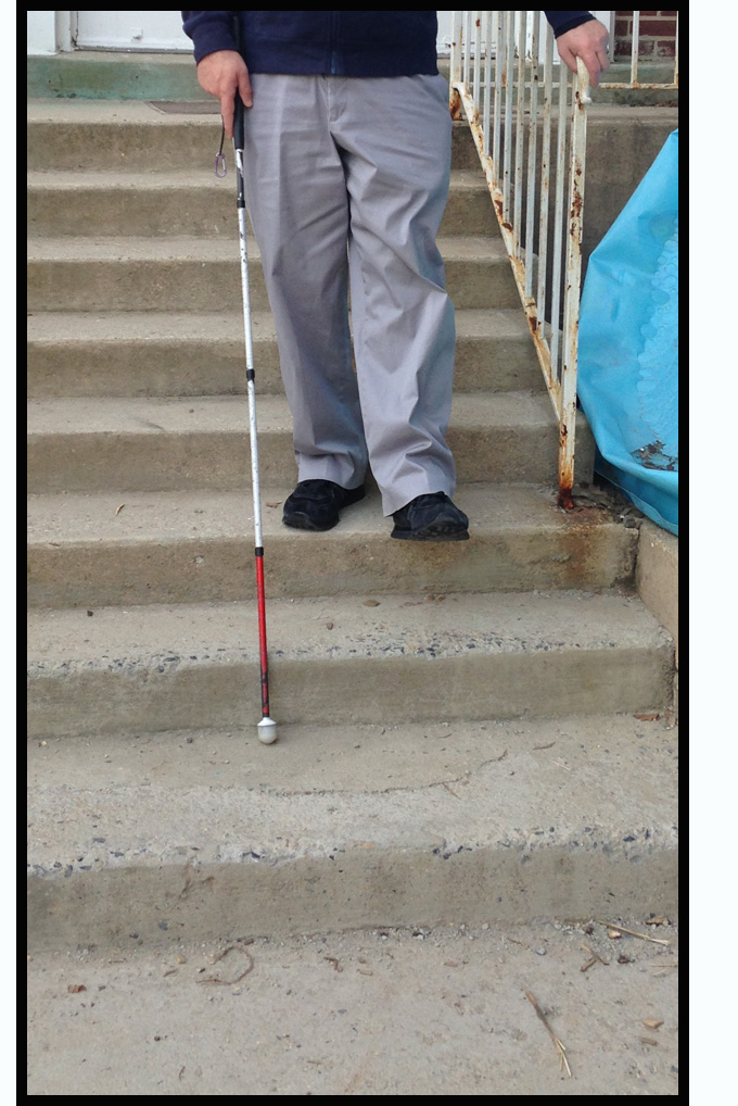 two photos show Randy coming down a flight of concrete steps with his right hand on the end of the railing and left hand holding his white cane.  He has one foot on the third step from the bottom and is extending his other foot to the next stair.